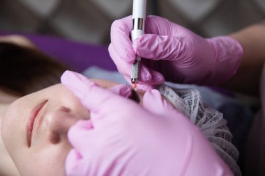 Kalıcı makyaj kaşları için. Microblading kaş. Şevval özçelik güzellik kadın yüzü için kaş dövme yapıyor. Güzel genç kız bir güzellik