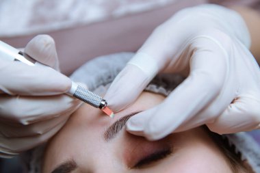 Kalıcı makyaj kaşları için. Microblading kaş. Şevval özçelik güzellik kadın yüzü için kaş dövme yapıyor. Güzel genç kız bir güzellik