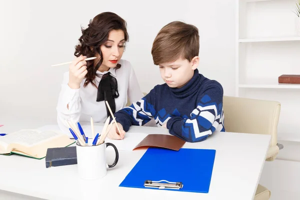 Nauczycielka pomaga teen chłopiec, aby zrobić swoją pracę domową. Odrabiania lekcji razem. — Zdjęcie stockowe