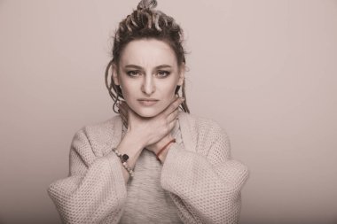 Kadın hasta hissediyor. Boğaz.