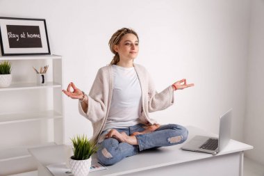 Kız ile dreadlocks yapmak yoga sırasında çalışma üstünde Laptop. Ofis Yoga.