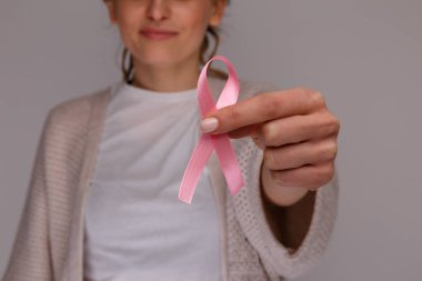 Pembe kurdele izole tutan kadının el.