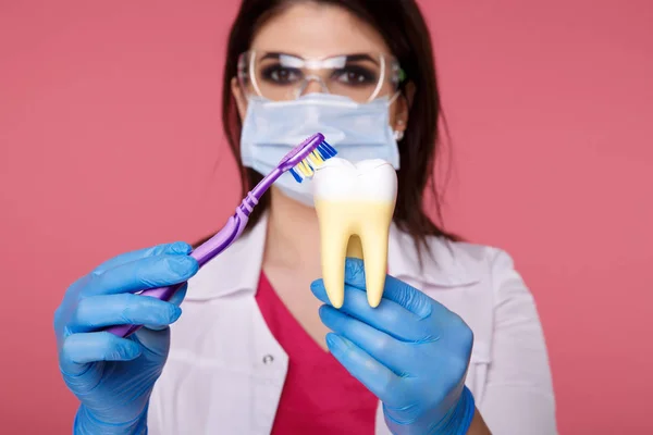 Biorąc pod uwagę jamy ustnej. Dentysta w masce pokazujący jak prawidłowo szczotkować zęby. — Zdjęcie stockowe