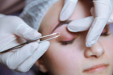 Kaş yapma süreci. Prosedürü kapalı gözleri ile güzel kadın.