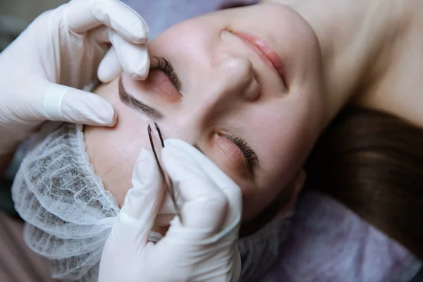 Processo di fabbricazione delle sopracciglia. Bella donna con gli occhi chiusi sulla procedura . — Foto Stock