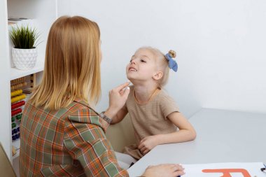 Konuşma terapisi kavramı. Kadın terapist eğitimi telaffuzu olan hasta çocuk.