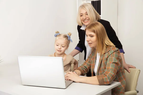 Gelukkig kind met grootmoeder en moeder met behulp van laptop samen. — Stockfoto