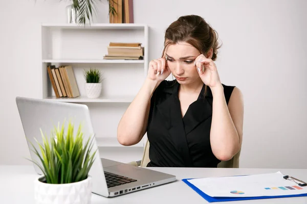 Trabajadora de oficina joven cansada y con dolor de cabeza. Concepto de migraña . — Foto de Stock