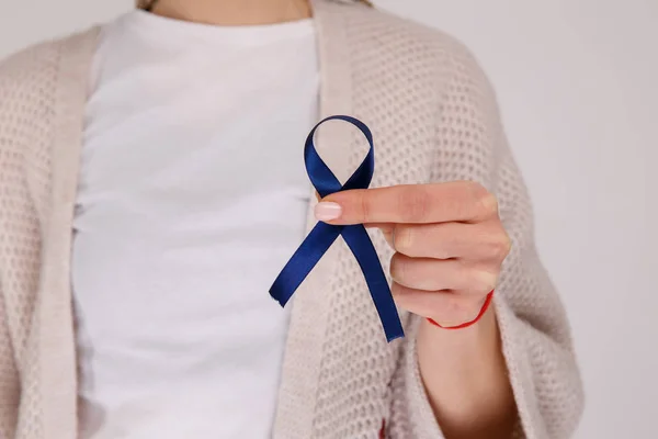 Vista de cerca de la cinta azul en la mano femenina. Cáncer de colon . — Foto de Stock