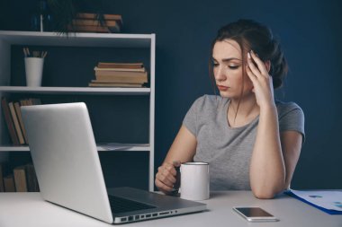 Gece işkadını ofiste oturuyor. Çalışmak için yorgun.