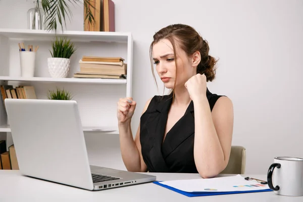 Nervous andangry woman in office closing her computer