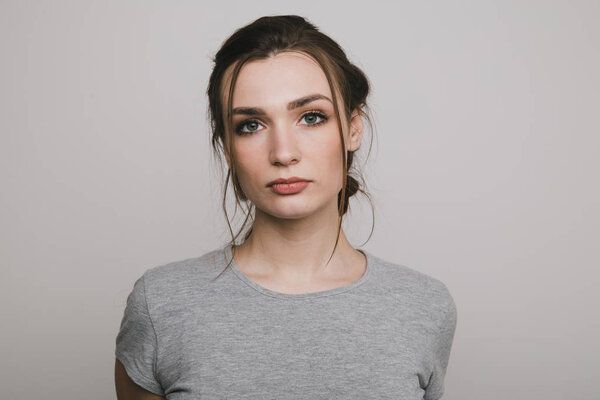 Portrait of a nice woman posing isolated over the grey background.