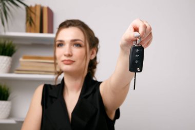 Otomatik saling sonra anahtarları veren kadın araba satıcısı.