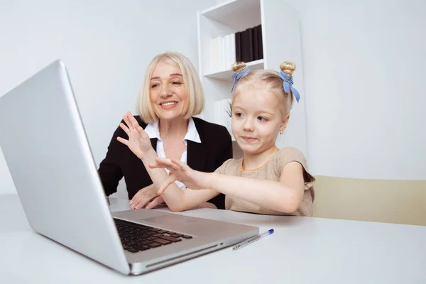 Meisje met oma zittend op het Bureau en het leren van iets door de computer. — Stockfoto