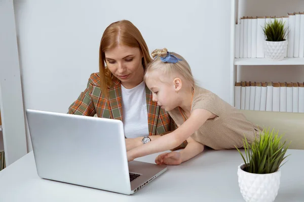 Moeder met dochter leren iets met behulp van computer indoor. — Stockfoto