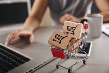 Online alışveriş. e-ticaret ve teslimat hizmeti kavramı: kağıt karton bir arabası ya da logo üstünde a laptop klavye trolley, perakendeci siteler internet üzerinden gelen müşteriler sipariş şeyler gösteriyor.