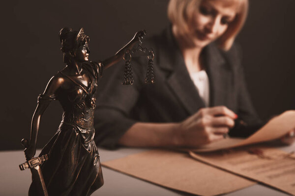 Closeup view of Themis on the desk. Female attorney concept.