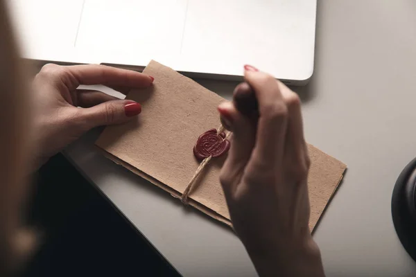 Rechter zegel op papier concept. Vrouwelijke handen met wax stempel geïsoleerd. — Stockfoto