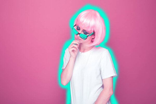 Симпатичная модель с розовыми волосами на фоне цвета единорога. Неоновая мода
