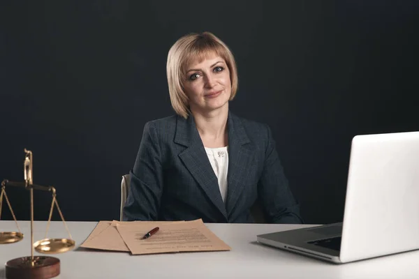 Rechtsanwältin sitzt an einem Arbeitsplatz und arbeitet mit Laptop. Frauenrechtliches Konzept. — Stockfoto