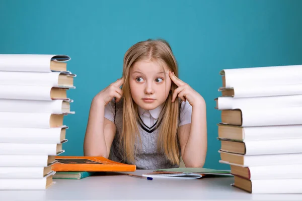 Tired teen girl with books on the background of a school board looking at camera. Space for text — Stock Photo, Image