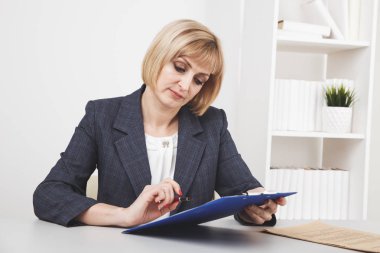 Sarışın kadın ofiste masada oturan ve çalışma.