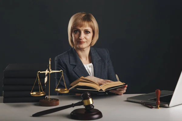 Advogada com livros jurídicos no seu local de trabalho. Gavel e libra na mesa . — Fotografia de Stock