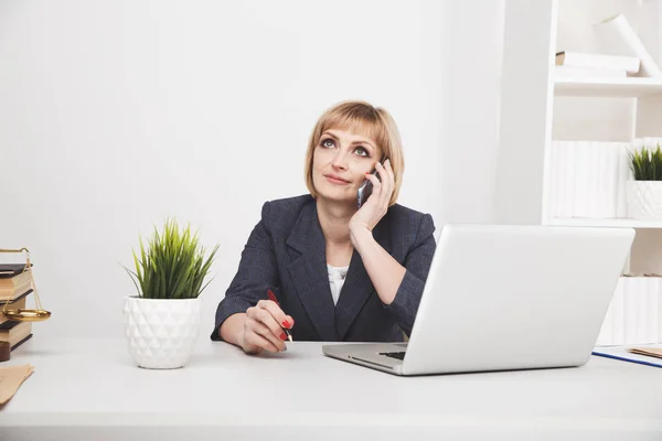 Secretaria mujer llamando sentada en su lugar de trabajo . — Foto de Stock