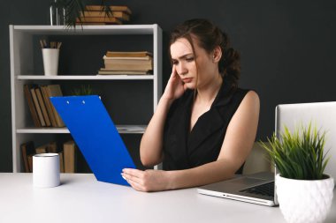 Çalışma alanında hasta ve yorgun bir ofis kadını. Baş ağrısı konsepti.