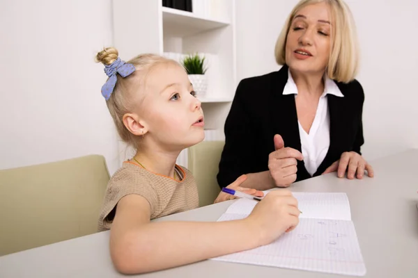 Vrouw counseling klein meisje binnen in de kamer. Psycholoog concept. — Stockfoto