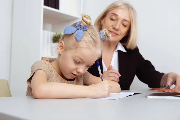 Picture of female tutor helping little girl. Teacher and pupil concept. — Stock Photo, Image