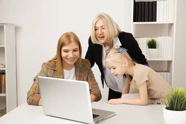 Gelukkig kind met grootmoeder en moeder met behulp van laptop samen. — Stockfoto