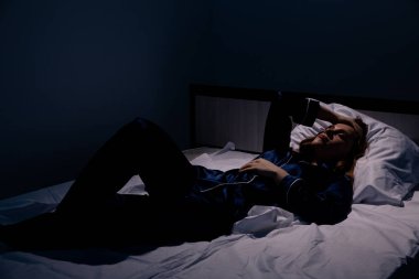 Uykusuz yatakta yatan üzgün kadın.