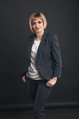 Stüdyoda takım elbiseli kadın gri arka planda izole.