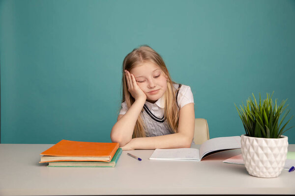 Уставшая девочка-подросток с книгами на фоне школьного совета, смотрящего в камеру. Пространство для текста
