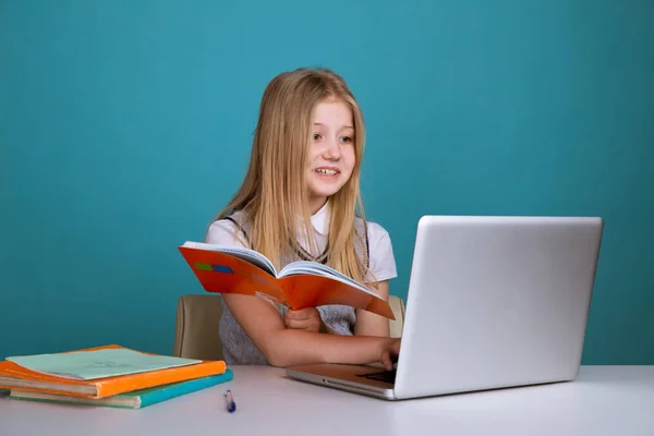 Hezká holka z puberty, co sedí blízko počítače s knižní izolovanou. — Stock fotografie