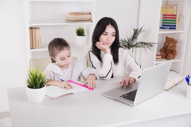 Anne ve çocuk kullanarak laptop birlikte ve öğretim internet.