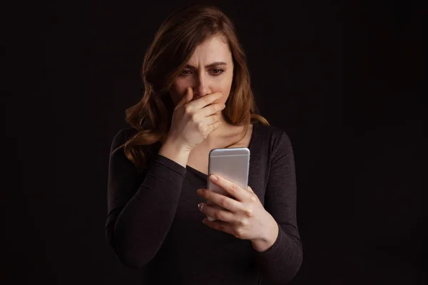 Serious frustrated girl holding phone in arm and do not understand what is going on.