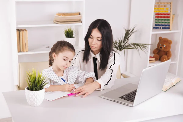 Moeder en dochter met behulp van laptop en Internet samen thuis. — Stockfoto