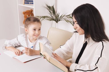 Anne kızı evde okuyor. Homwschool konsepti.