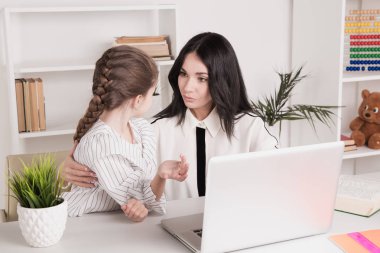 Anne ve kızı evde birlikte laptop ve internet kullanarak.