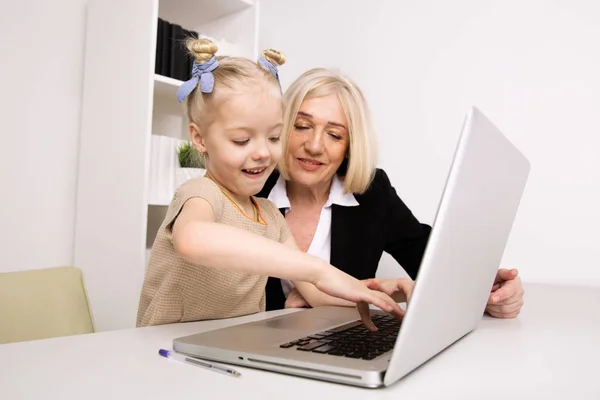 Meisje met oma zittend op het Bureau en het leren van iets door de computer. — Stockfoto