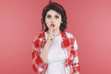 Sessiz kırmızı stüdyo üzerinde izole tutmak için gösteren güzel bir kadın.