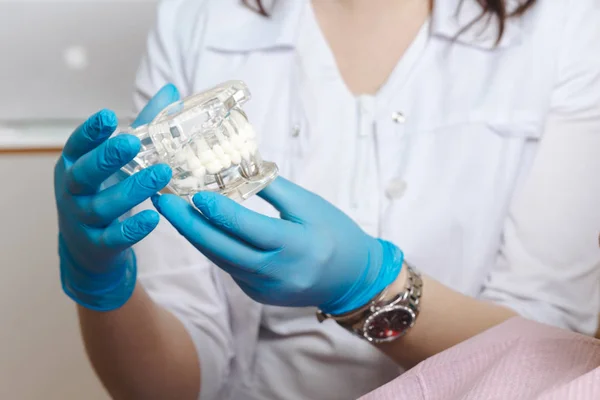 Стоматолог в синіх рукавичках, що показує блідість кольору зуба . — стокове фото