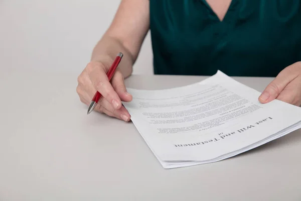 Foto de cerca de las manos de las mujeres sosteniendo documentos de papel y un bolígrafo sentado en el escritorio . — Foto de Stock