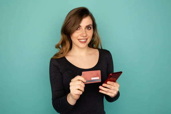 Conceito de compras online. Jovem segurando cartão de crédito e fazendo compras por telefone . — Fotografia de Stock