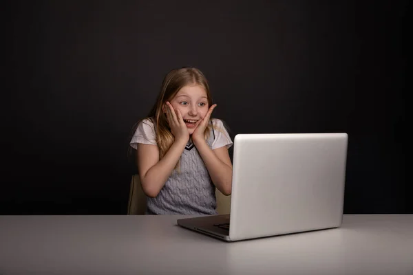 Menina feliz na frente do laptop digitação isolado . — Fotografia de Stock