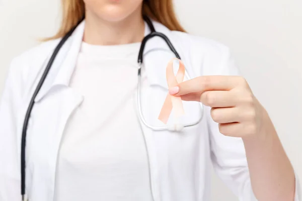 Ribbone naranja en los médicos mano aislada . — Foto de Stock