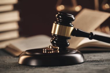 Bir ağaçtan kırık bir kalp figürü üzerinde Alyans, ahşap bir arka plan üzerinde bir yargıç çekiç. Boşanma boşanma işlemleri