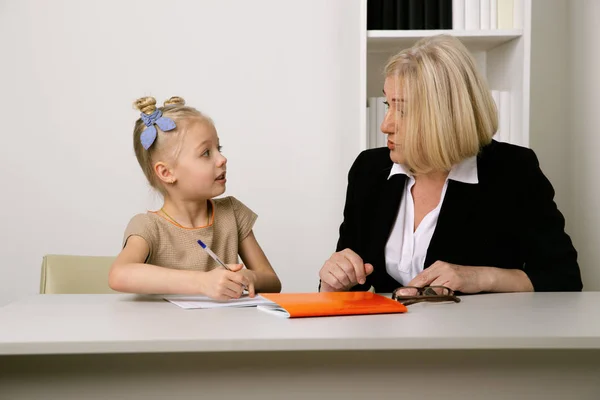 Conceito de professor e aluno. Tutor ajudando com lição de casa para a menina . — Fotografia de Stock